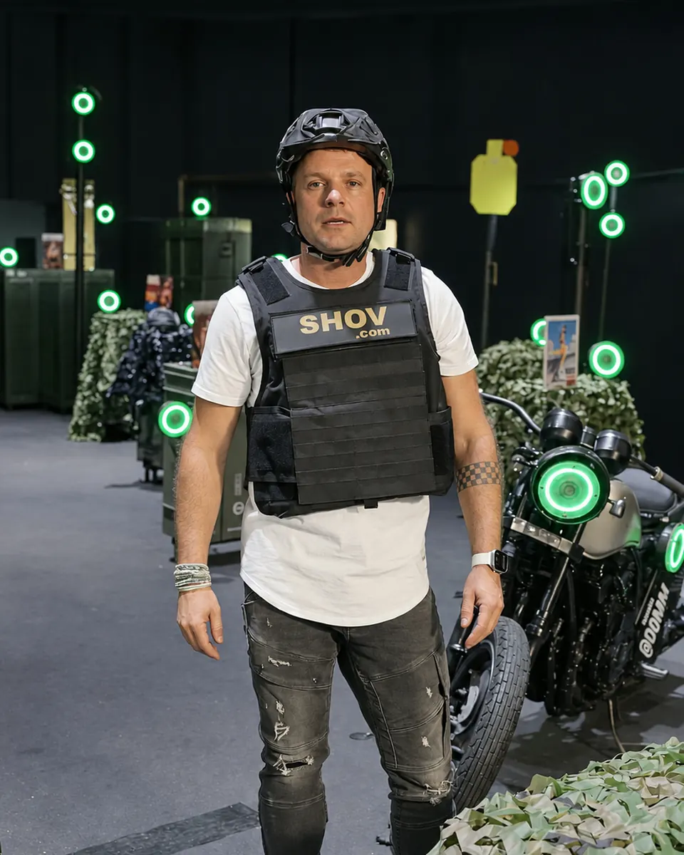 A player in a SHOV vest and helmet standing among lit ring targets inside the arena